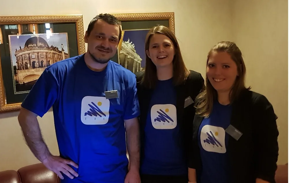 Drei Personen in blauen T-Shirts mit EWA-App-Logo