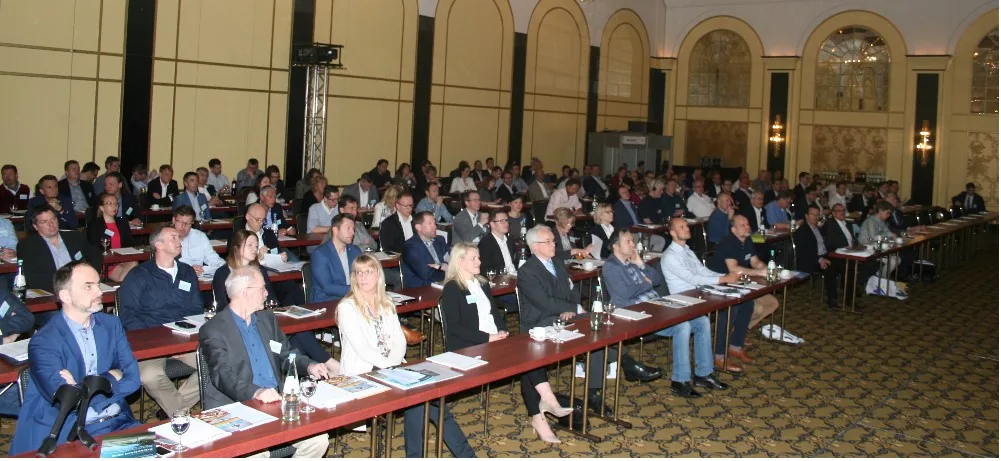 Teilnehmende einer Konferenz in einem großen Saal