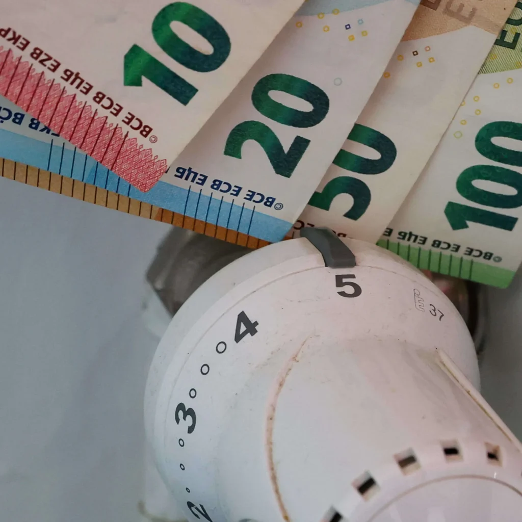 Euro-Geldscheine neben einem Heizungsregler