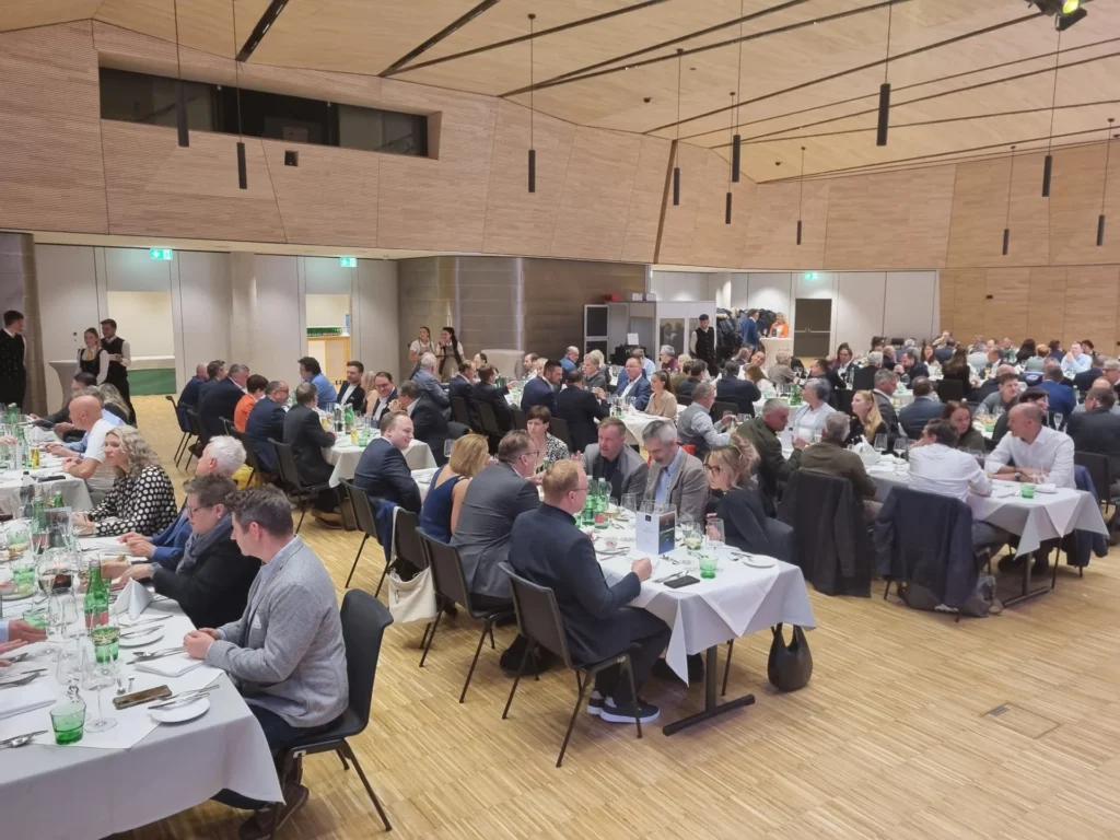Konferenzpublikum an runden Tischen in einem modernen Saal