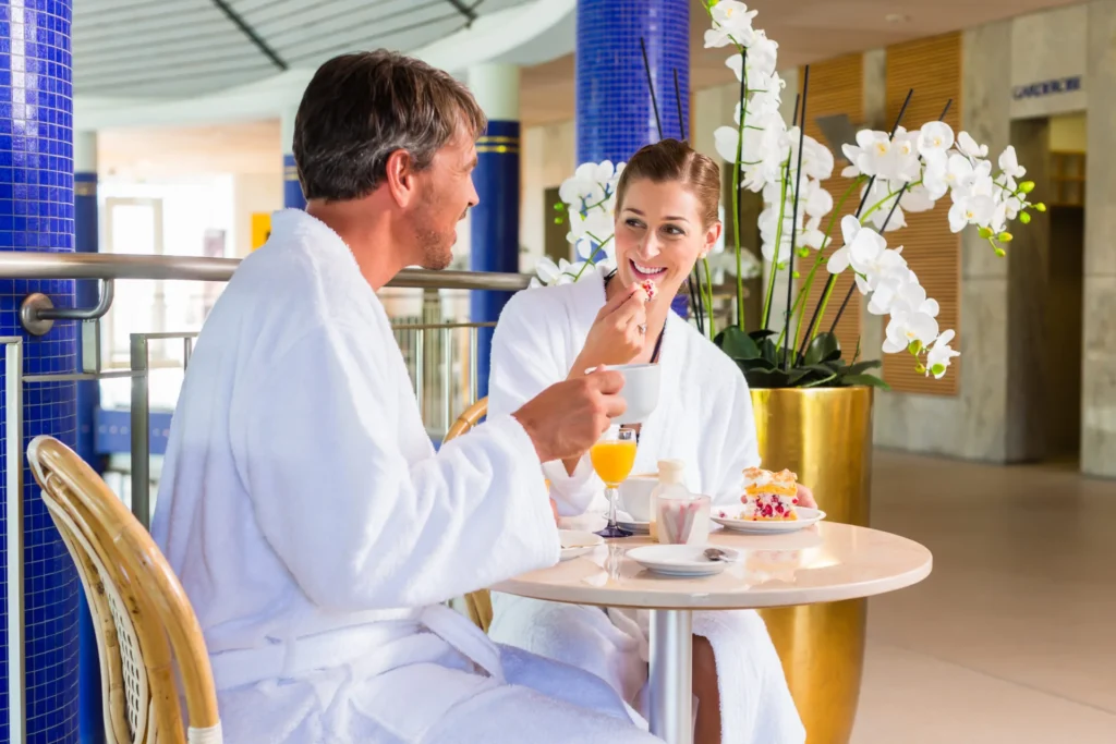 Mann und Frau im Bademantel beim Frühstück in einem Spa