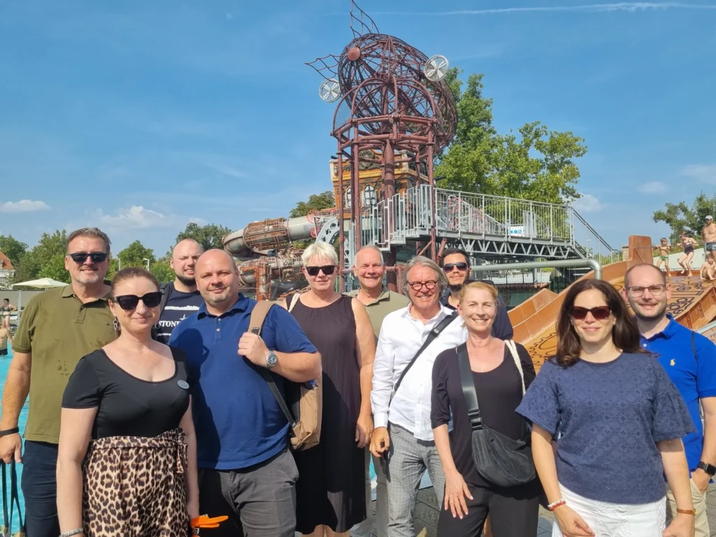 Reisegruppe vor einer Achterbahn im Freizeitpark