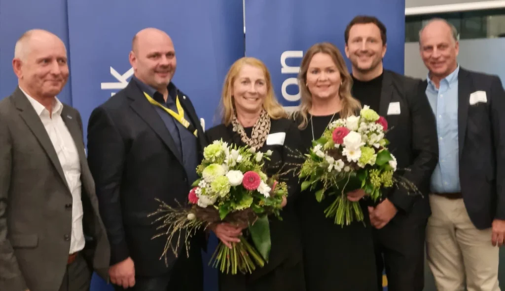 Gruppe bei einer Ehrung mit Blumenstrauß