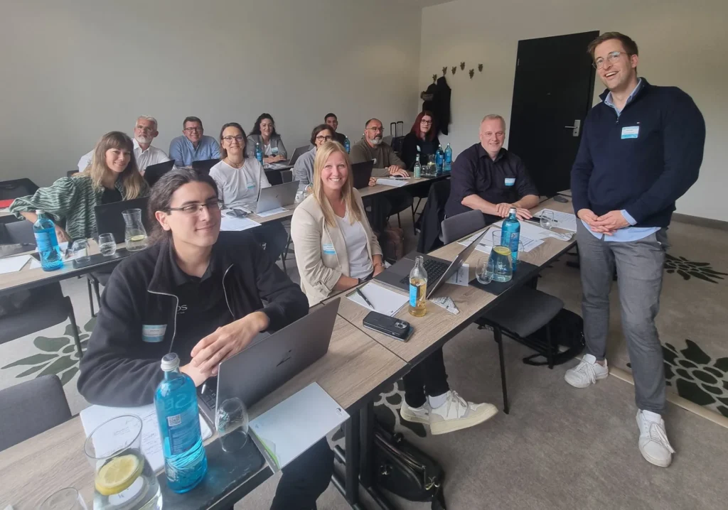 Teilnehmende eines Workshops an Tischen mit Laptops