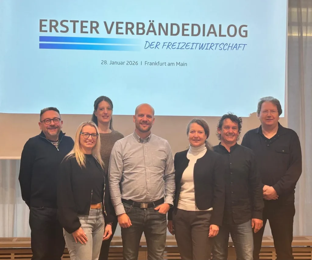 Gruppe vor einer Präsentationsfolie zum Verbändedialog