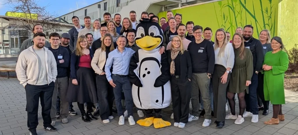 Große Gruppe vor einem Wandbild mit einem Pinguin