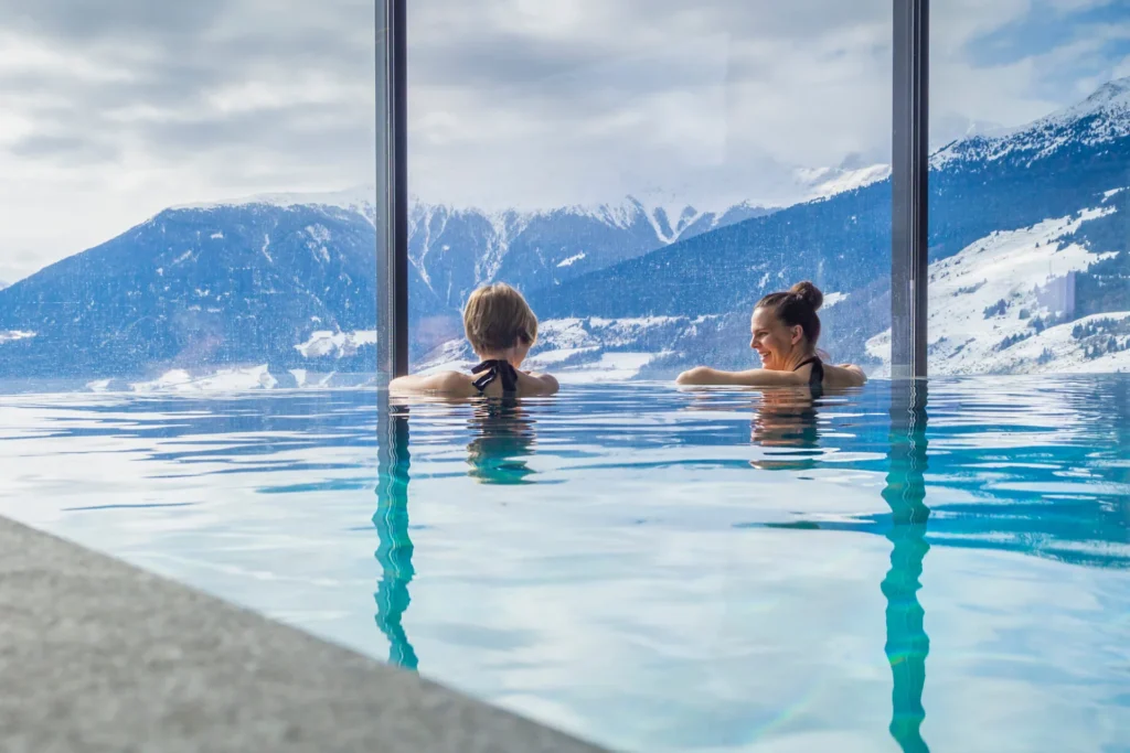 Zwei Personen im Infinity-Pool mit Bergblick