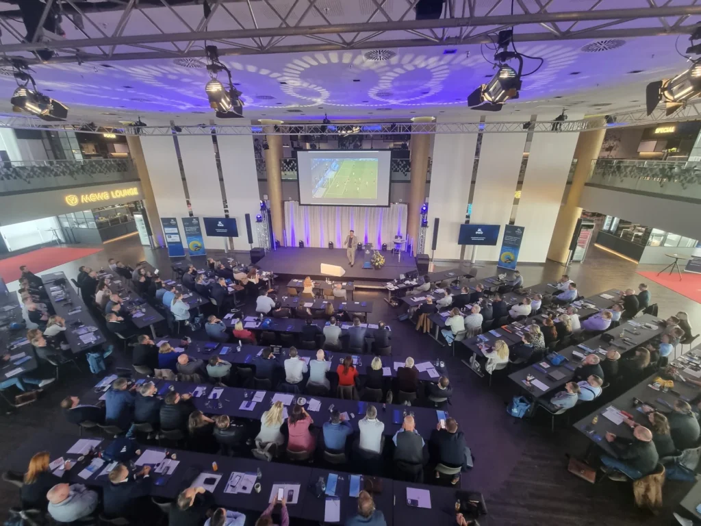 Großer Konferenzsaal mit Bühne und Publikum