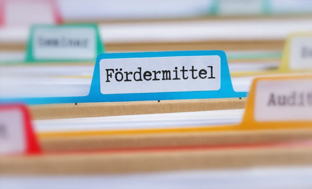 Ordner mit dem Aufdruck Fördermittel in einem Aktenregal