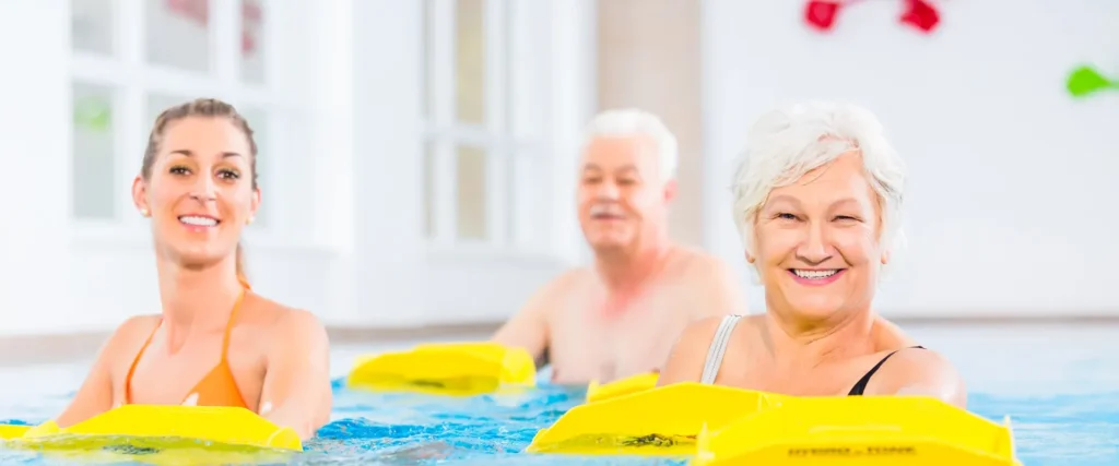 Menschen unterschiedlichen Alters beim Aquatraining im Hallenbad